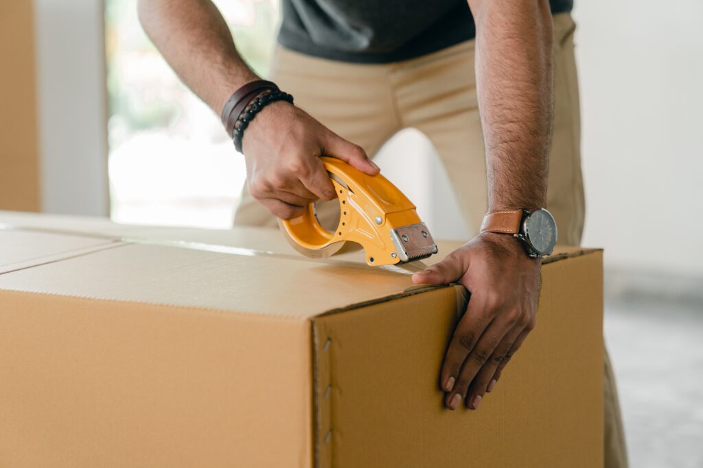 Buy Your House: A man is packing a box