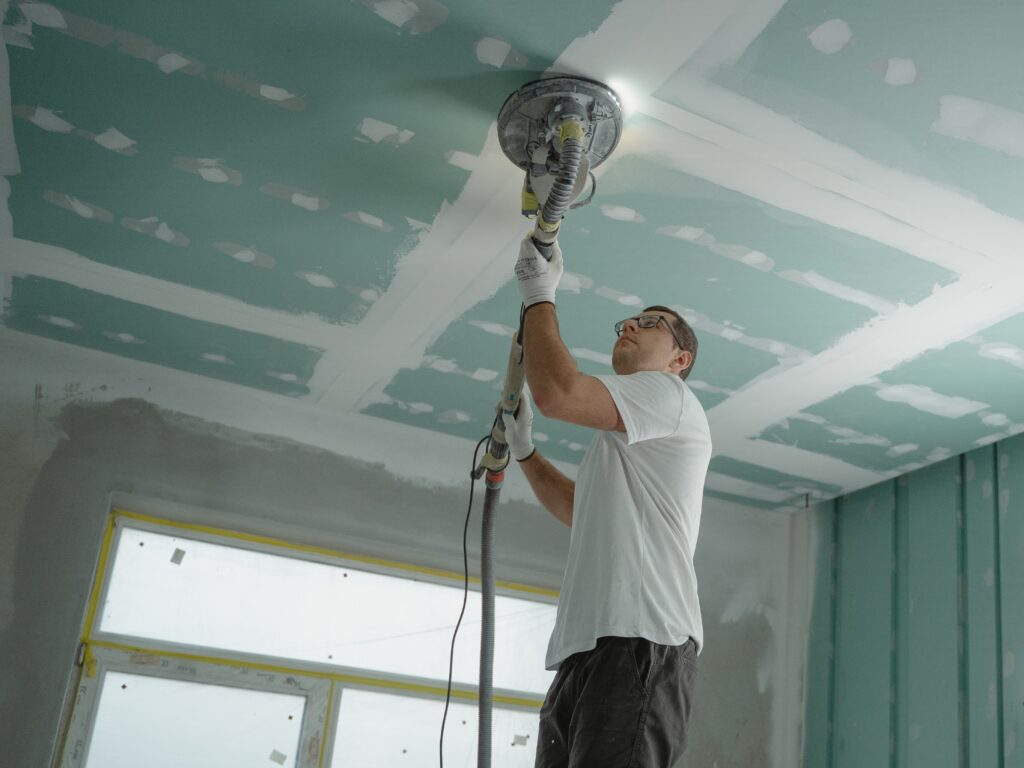 Newly Built Home: A man is working on a the ceiling of the house
